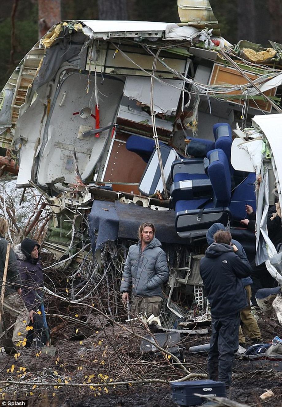 Disaster area: Brad sported a grey puffa jacket and military style khaki trousers on the set in the middle of the English countryside