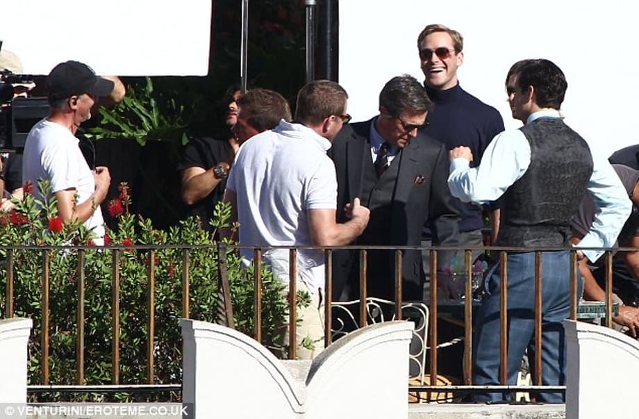 Getting stuck in: Hugh appeared serious as he and Henry listened to director Guy while Armie couldn't resist having a laugh