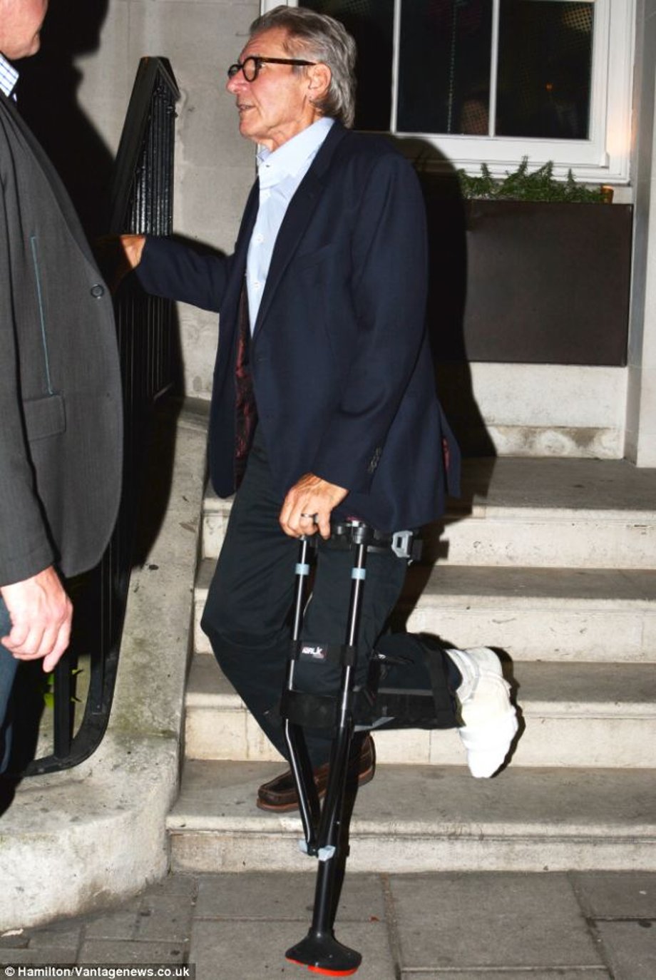 Fighting back: Harrison Ford, 71, refused helping hands from friends as he hobbled down a flight of stairs using a prosthetic peg leg for support after breaking his foot on the set of Star Wars: Episode VII